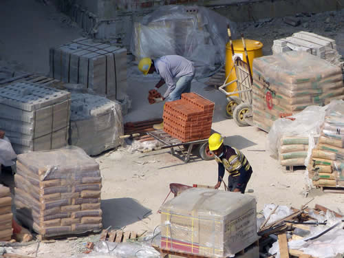 ouvriers portent des charges lourdes sur un chantier