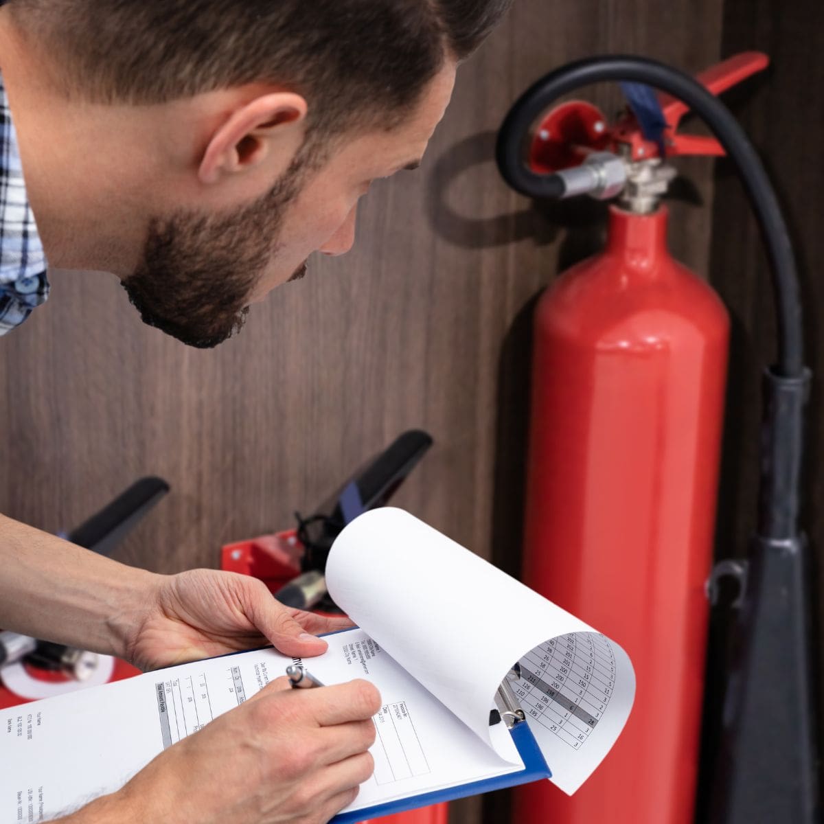 personnel spécialisé en incendie effectuant une maintenance d'un extincteur