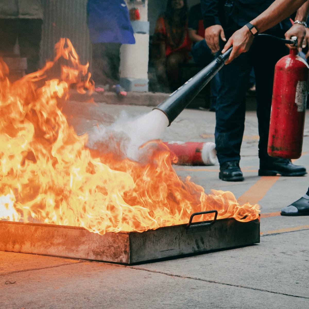 Personne en formation Permis Feu apprend à manipuler un extincteur sur feu réel