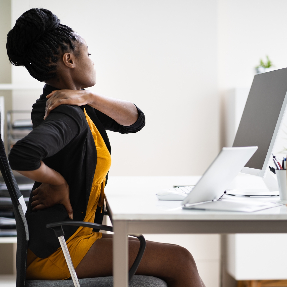 femme assise à son bureau ayant des douleurs cervicales - cas pratique étudié en formation pour les formateurs PRAP