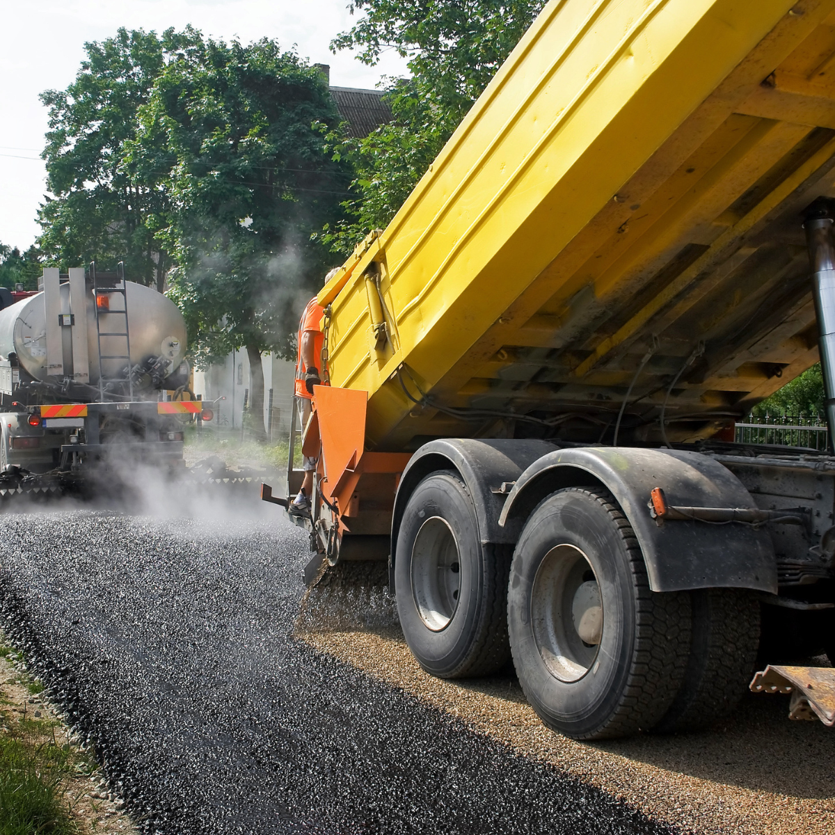 vue d'un engin de chantier réalisant l'enrobé d'une route proche des réseaux