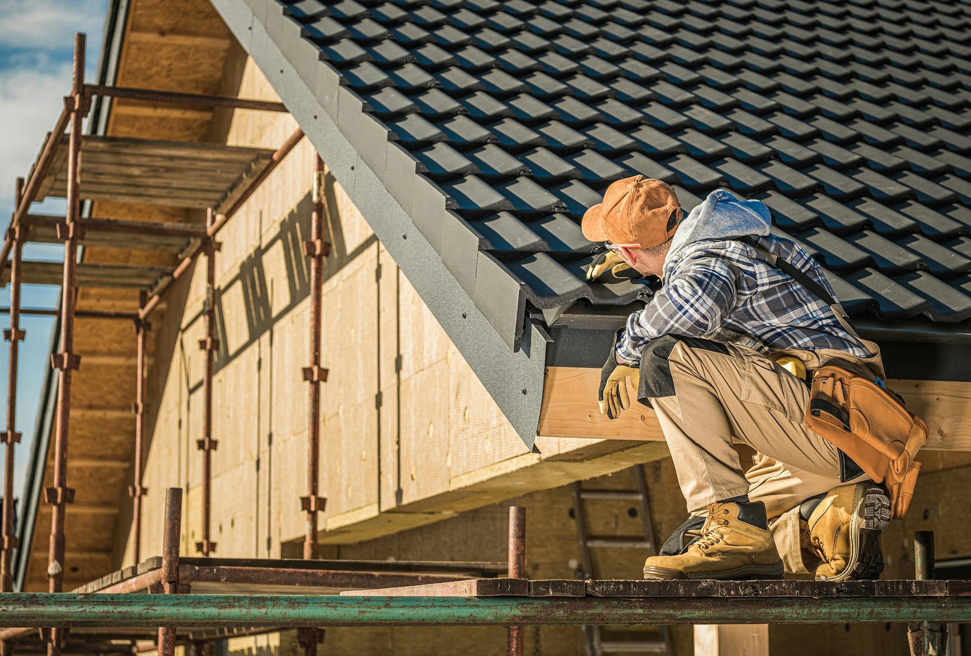 man working on a roof with a hammer and a saw