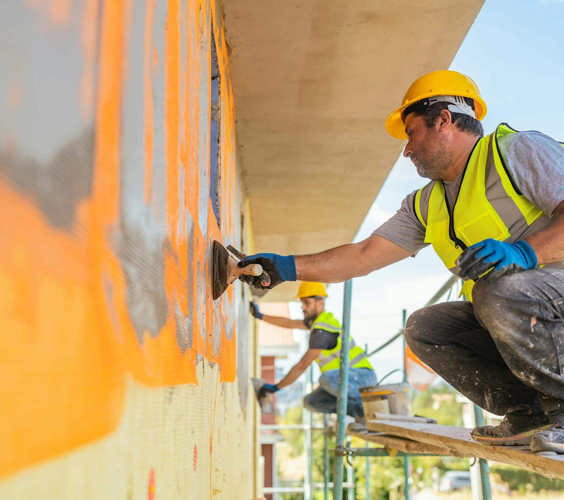 construction worker painting a wall with a paint brush
