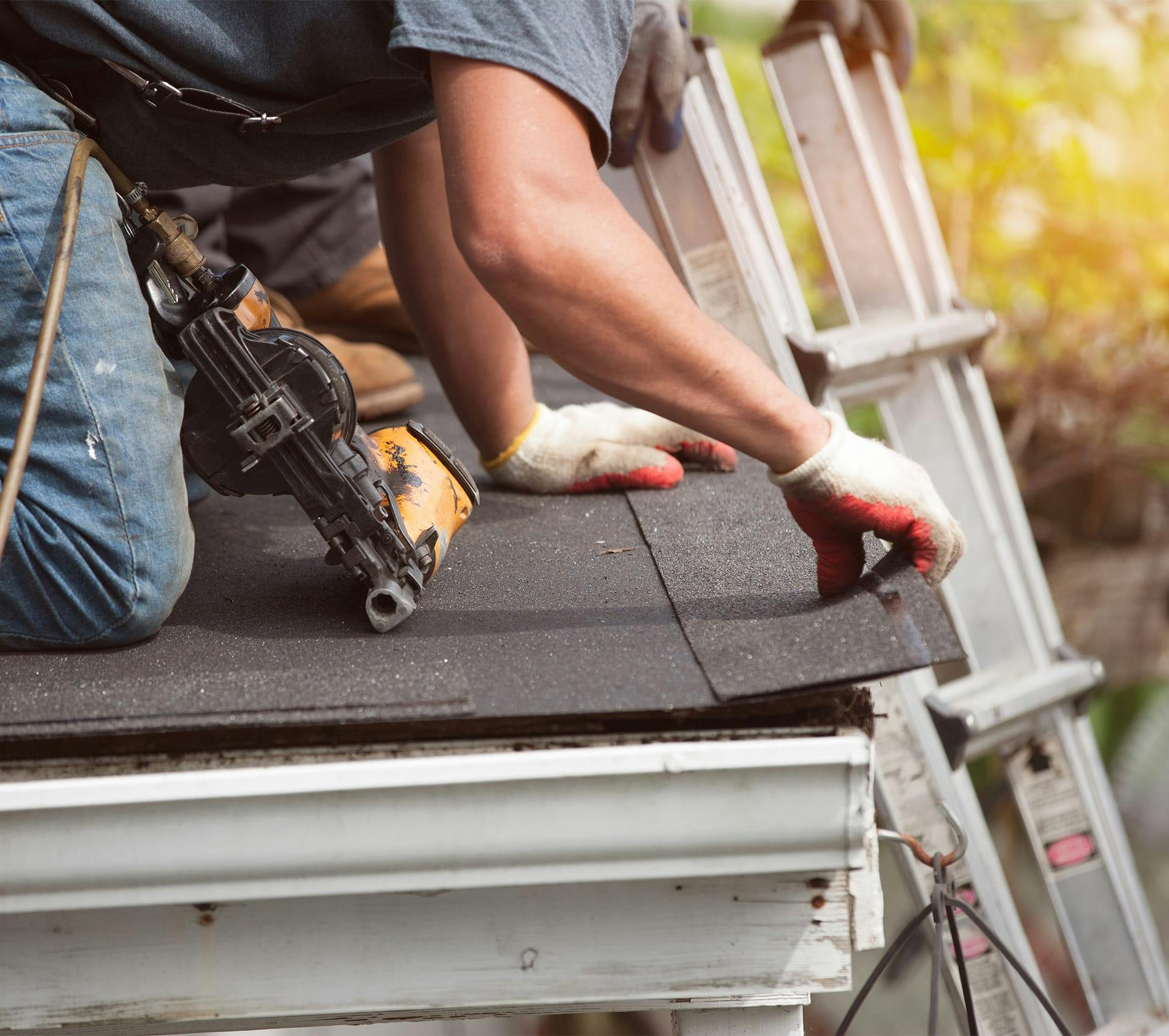 man laying a piece of metal on a roof