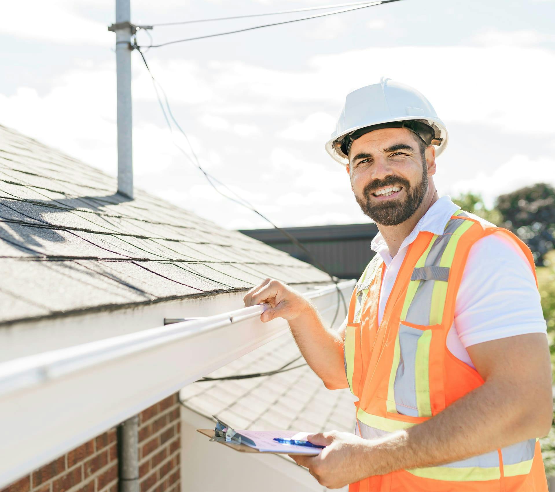 man in safety vest holding clipboard and pointing at something