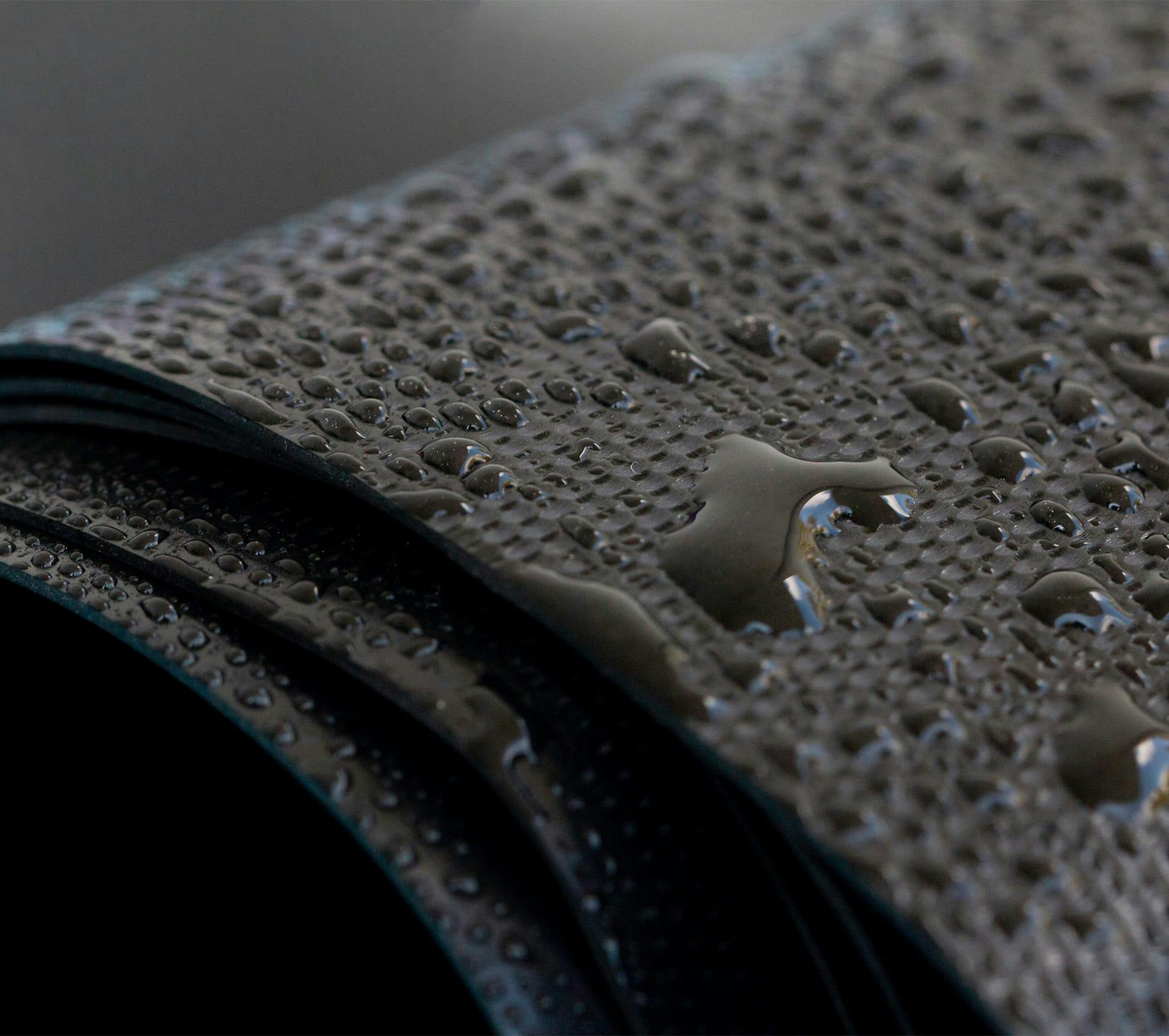a close up of roofing materials with water droplets on it
