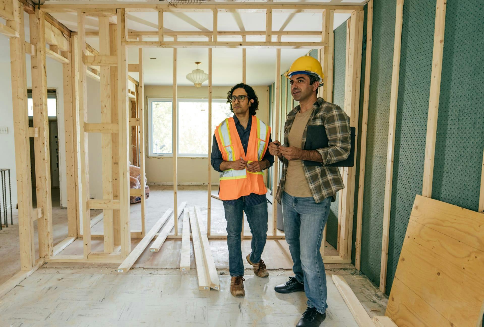construction workers standing in a room with unfinished walls