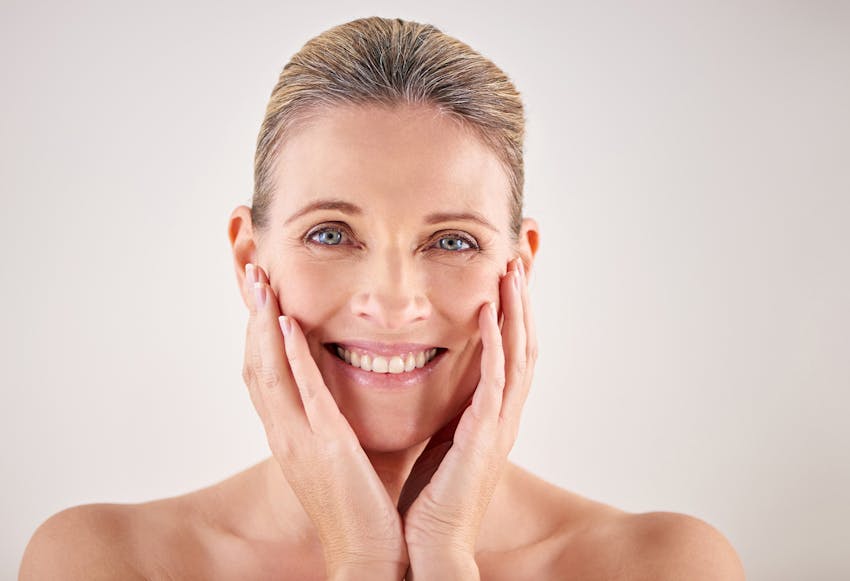 Woman smiling with her hands on her cheeks