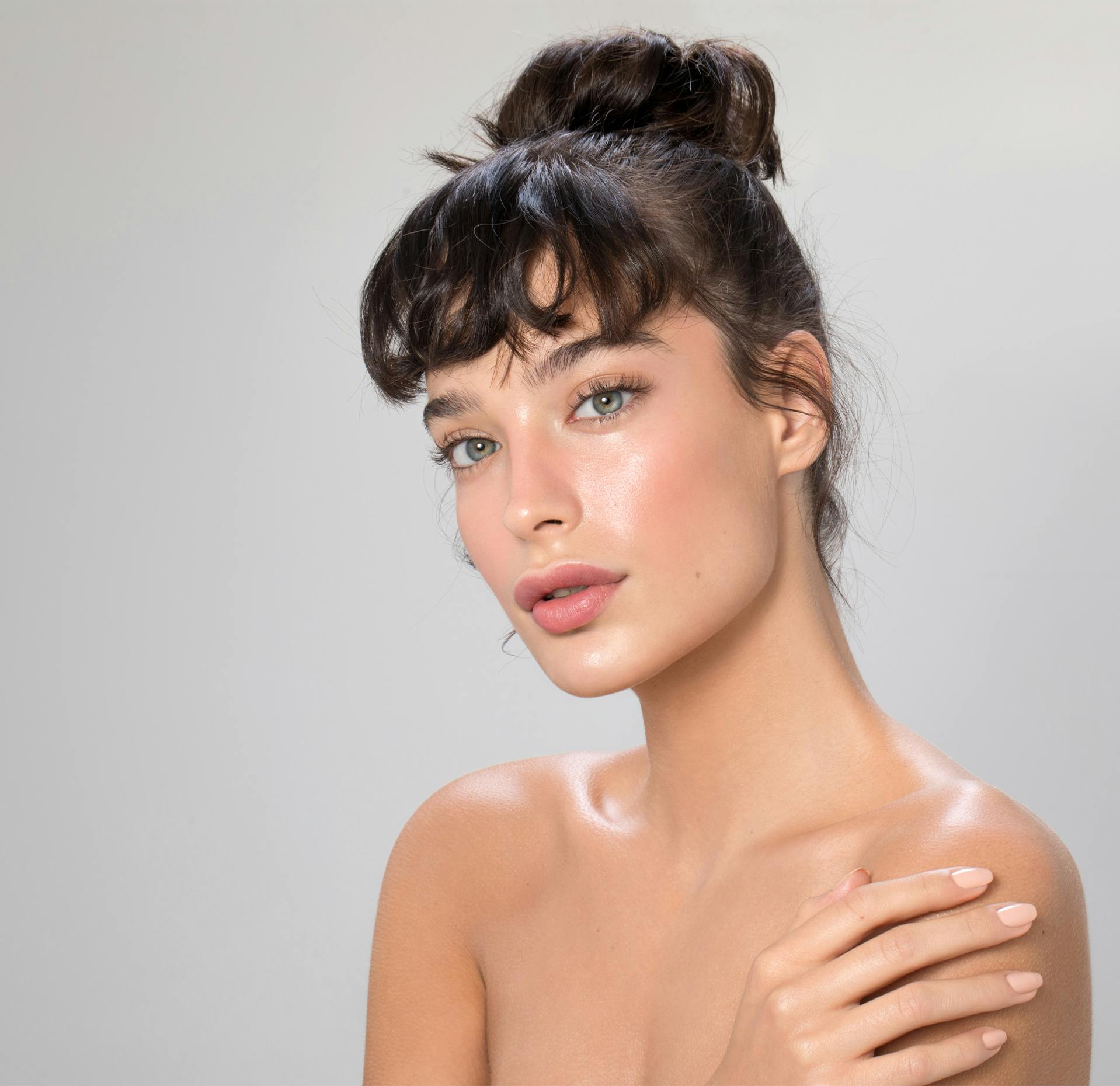 close up of a woman with her hair up in a bun posing for picture