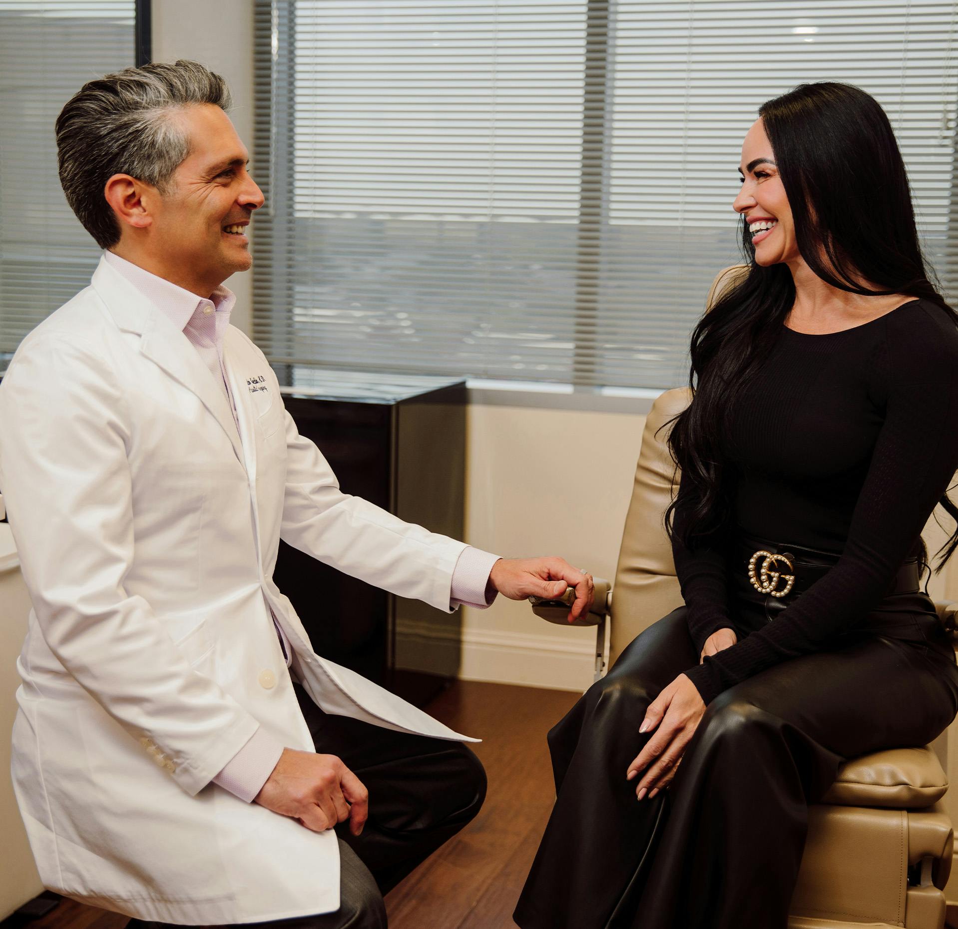 Dr. Ricardo A. Meade siting down and talking with patient