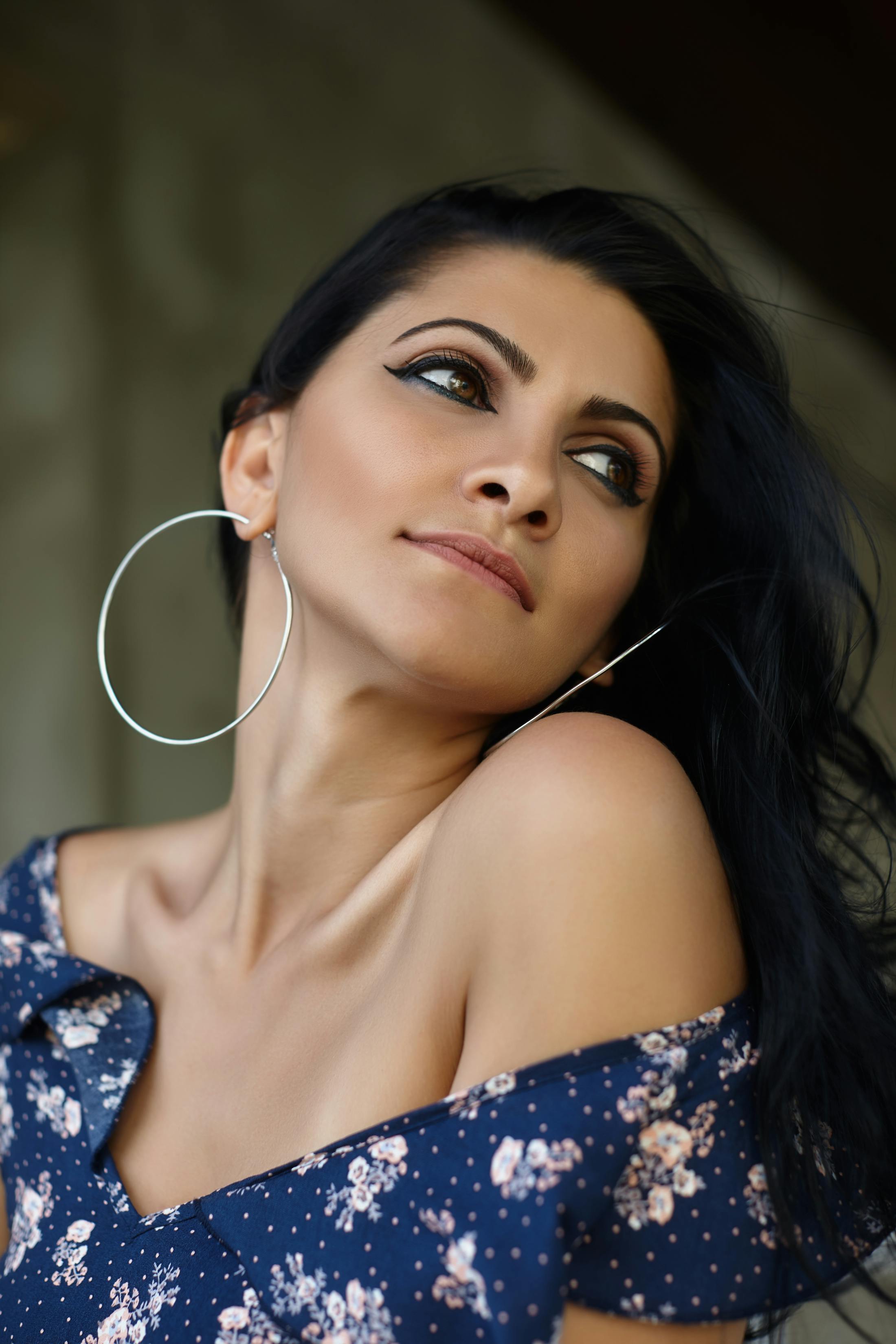 there is a woman with a blue dress and large hoop earrings