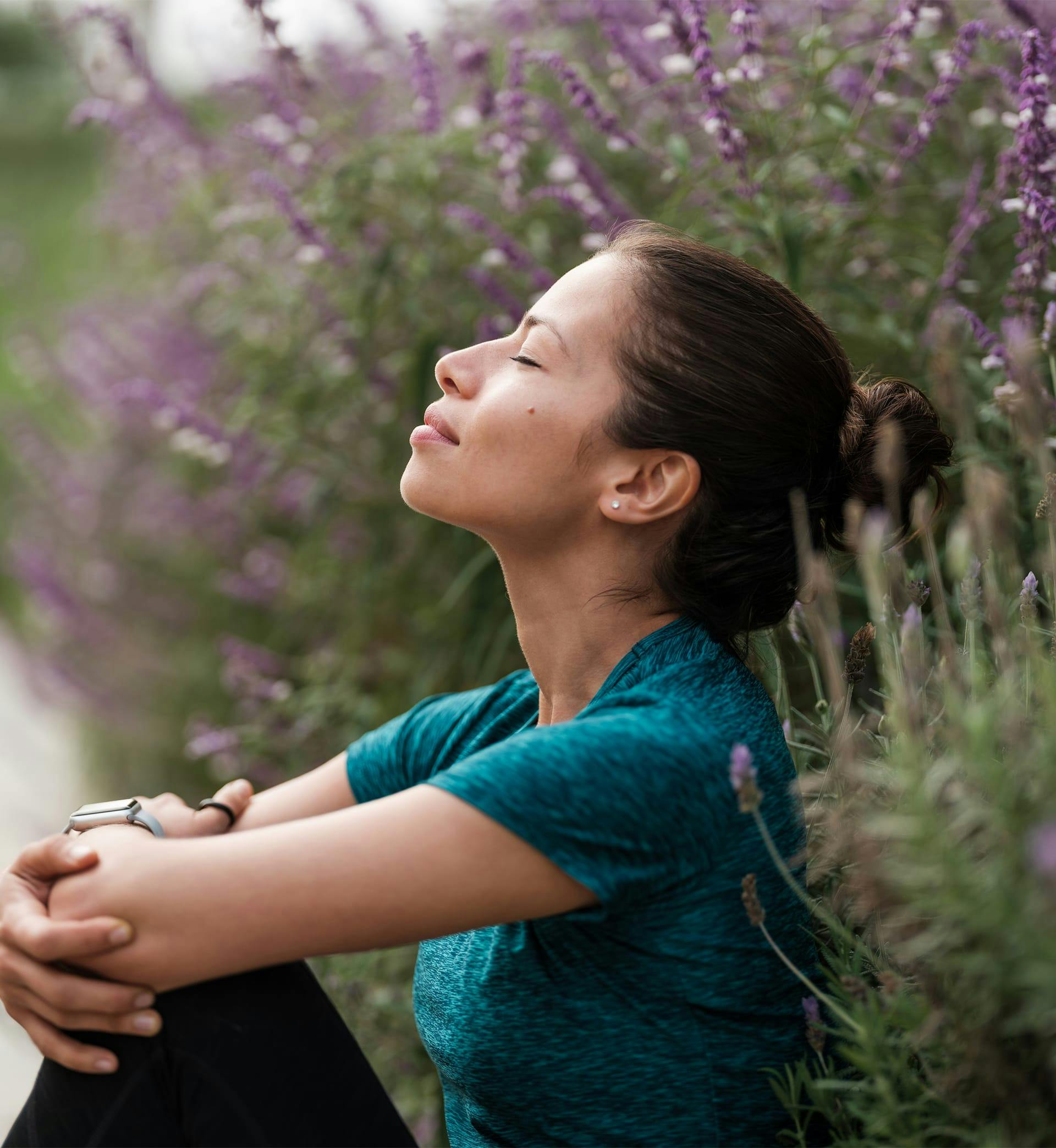 A woman sitting outside with eyes closed