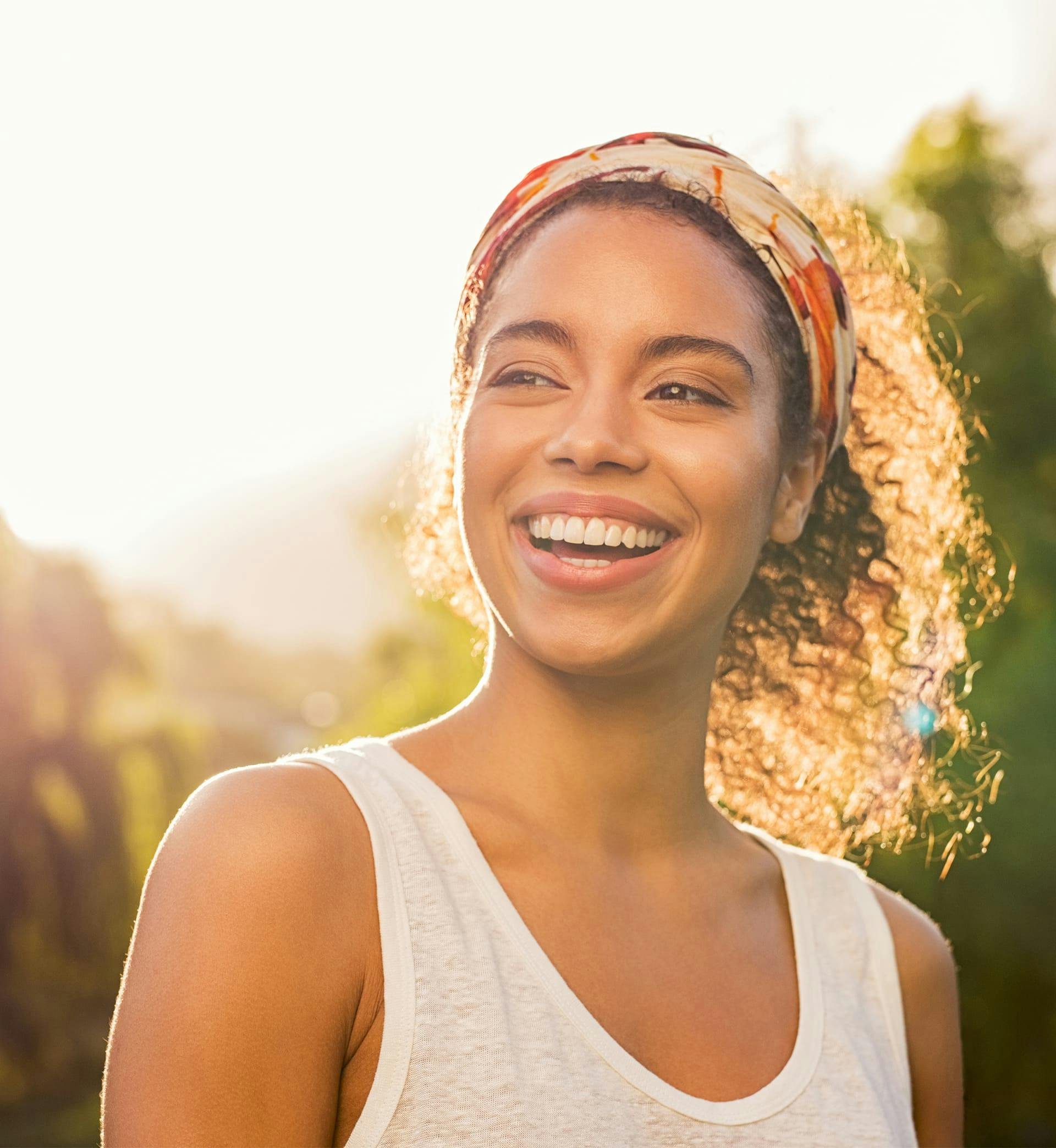 Woman in tank top smiling outside