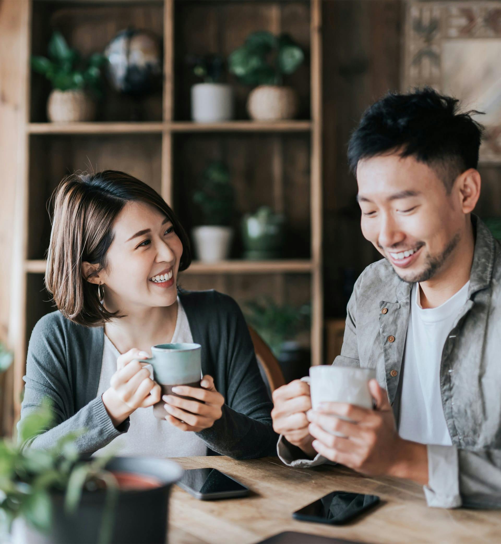 A man and woman holding cups smiling