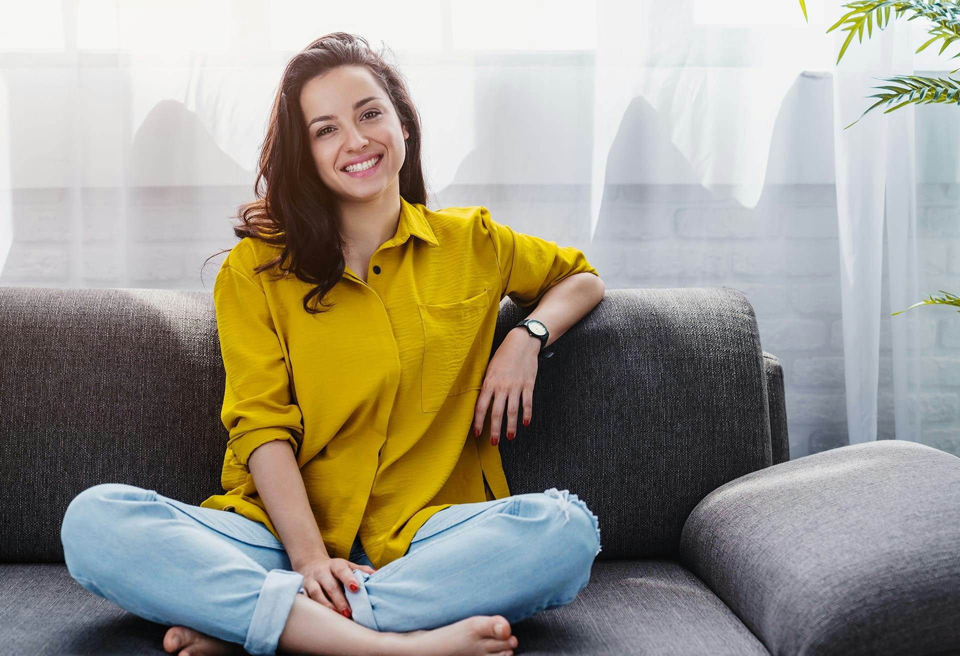 Woman in yellow top sitting on couch