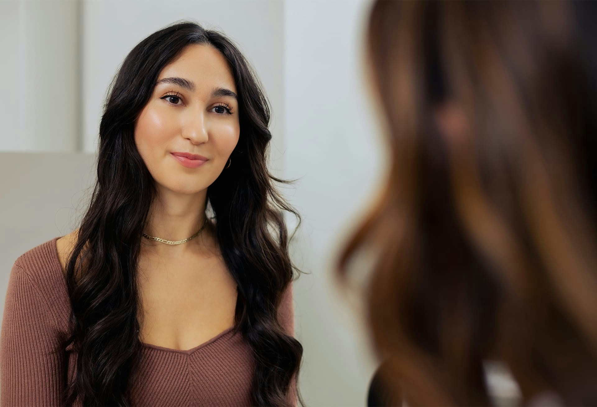 Woman with long hair looking in the mirror