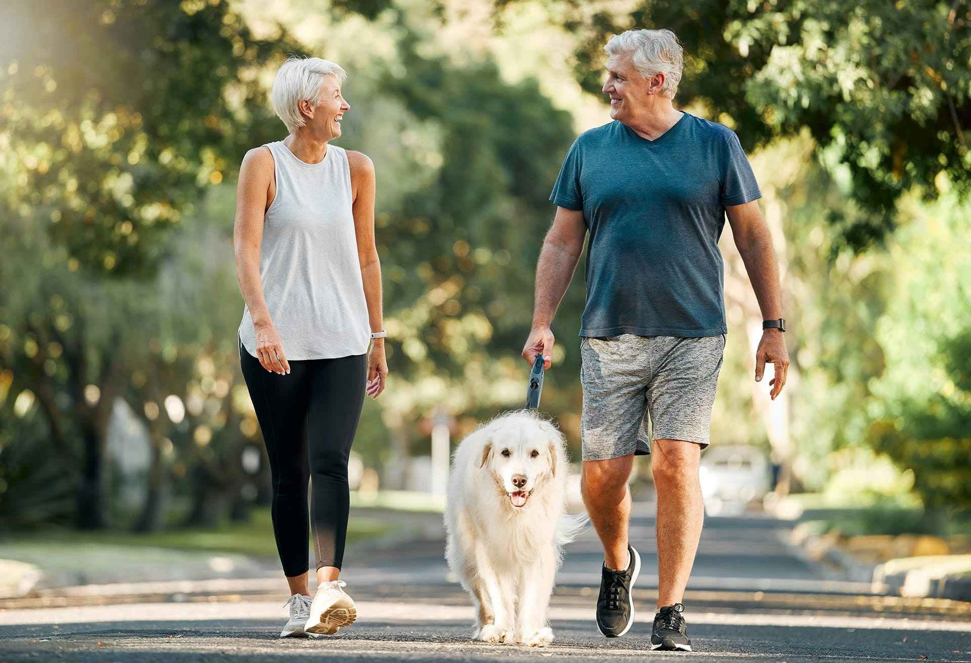 Older couple happily walking dog