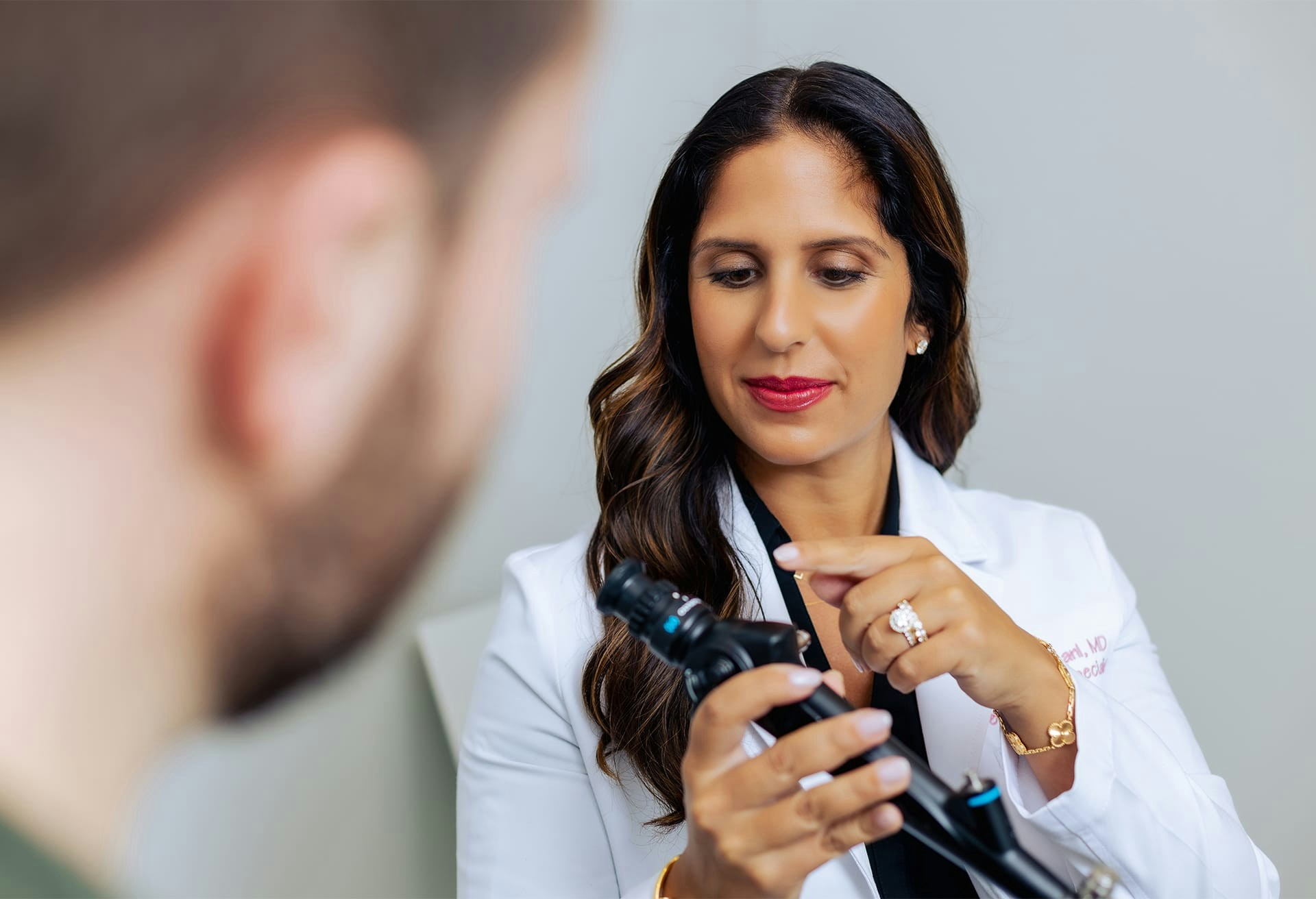 Dr. Sonia Bahlani using medical equipment while speaking to a patient