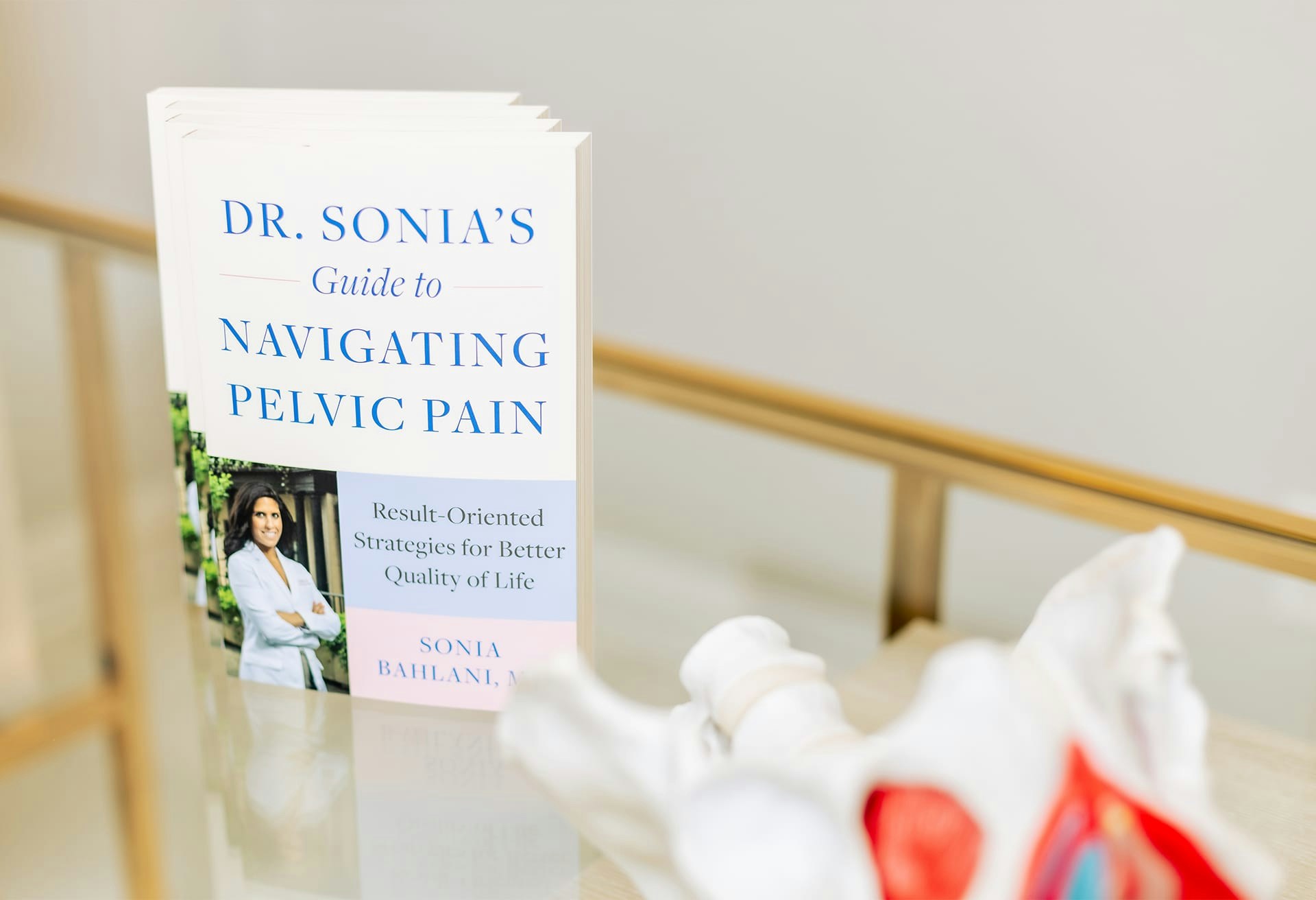 A table with Dr. Sonia's Guide to Navigating Pelvic Pain book propped up
