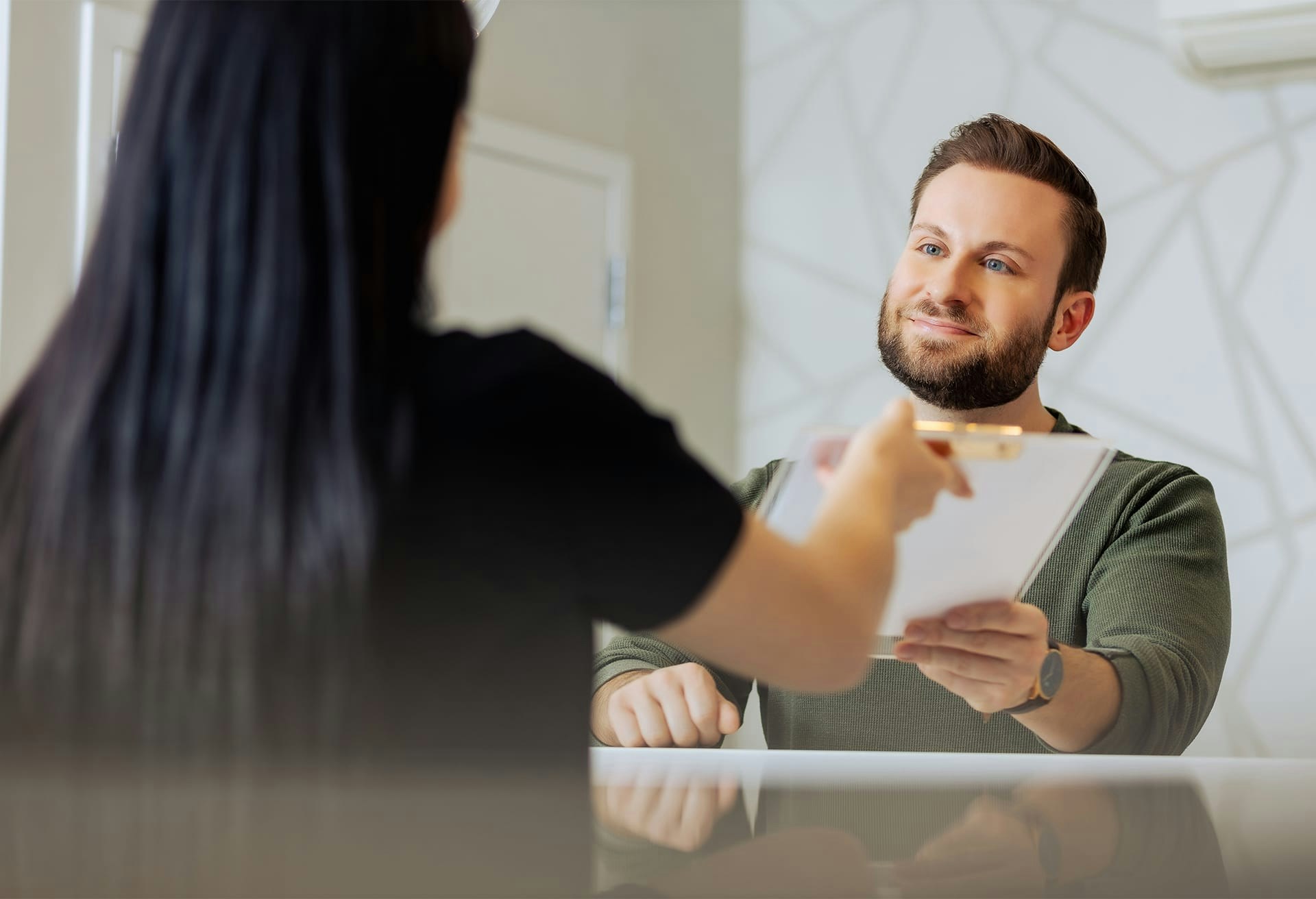 Man handing woman a clipboard