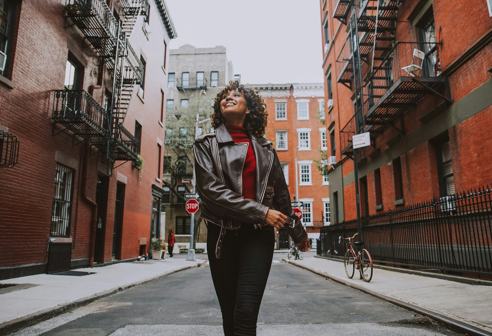 Woman wearing a black leather jacket walking in the city