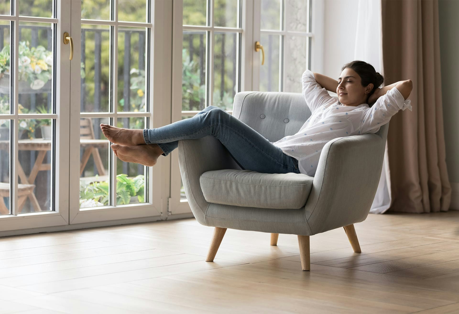 Woman leaning back in chair with her hands behind her head