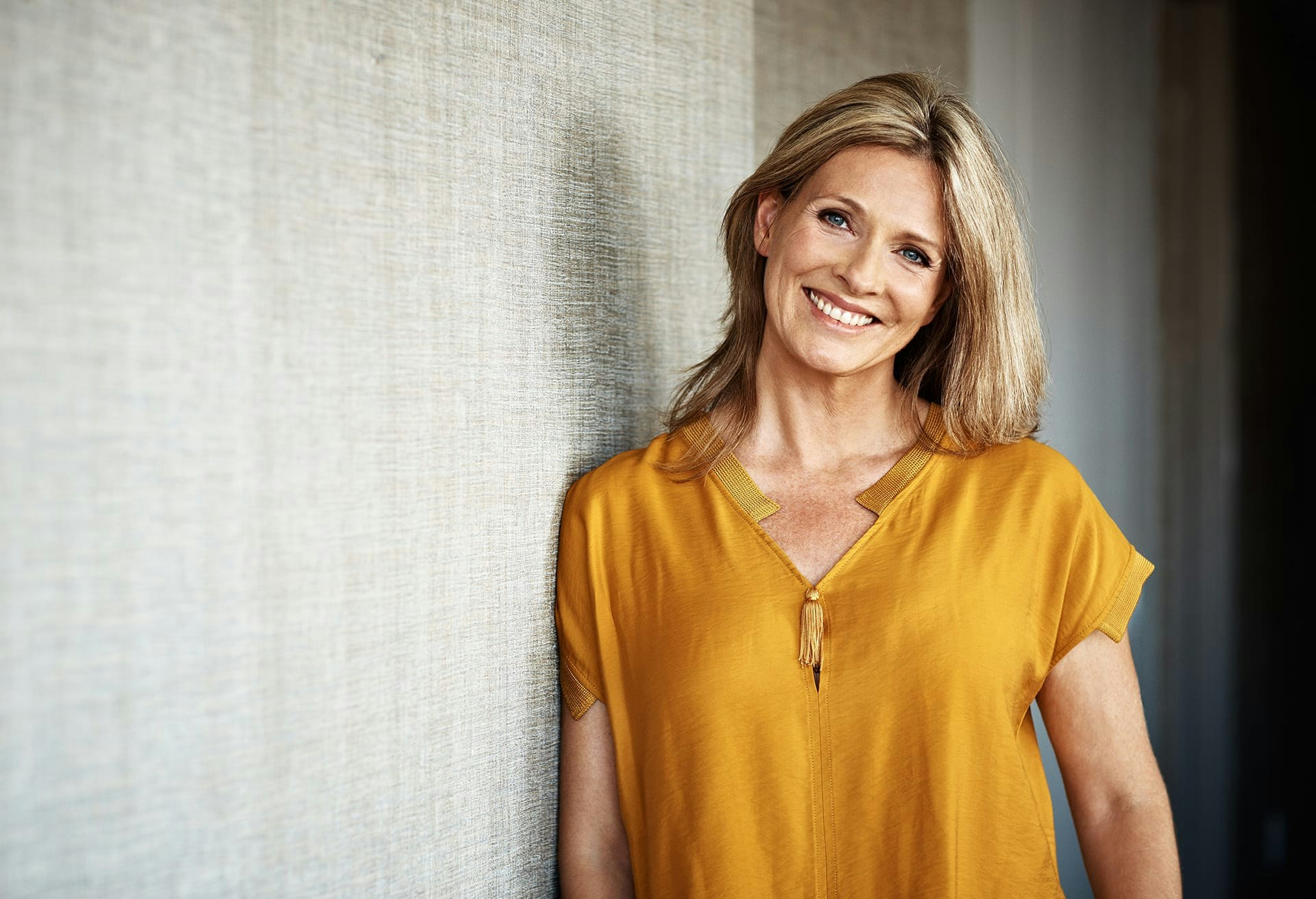 Woman wearing a yellow blouse smiling