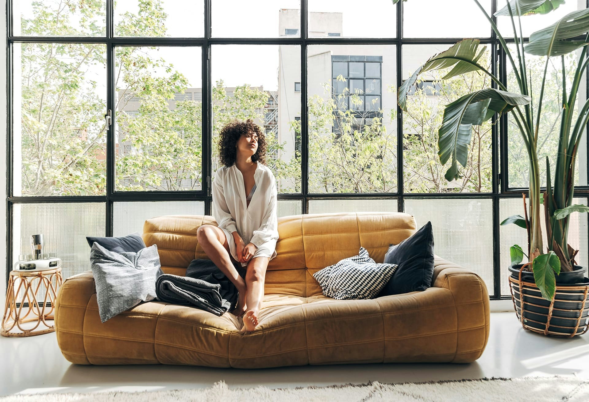 Woman sitting on a couch in front of a window