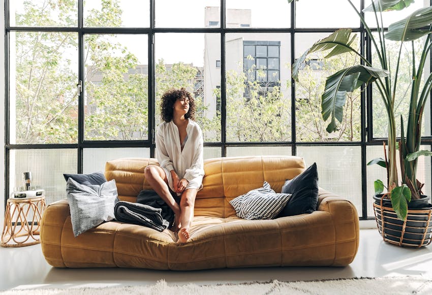 Woman sitting on a couch in front of a window