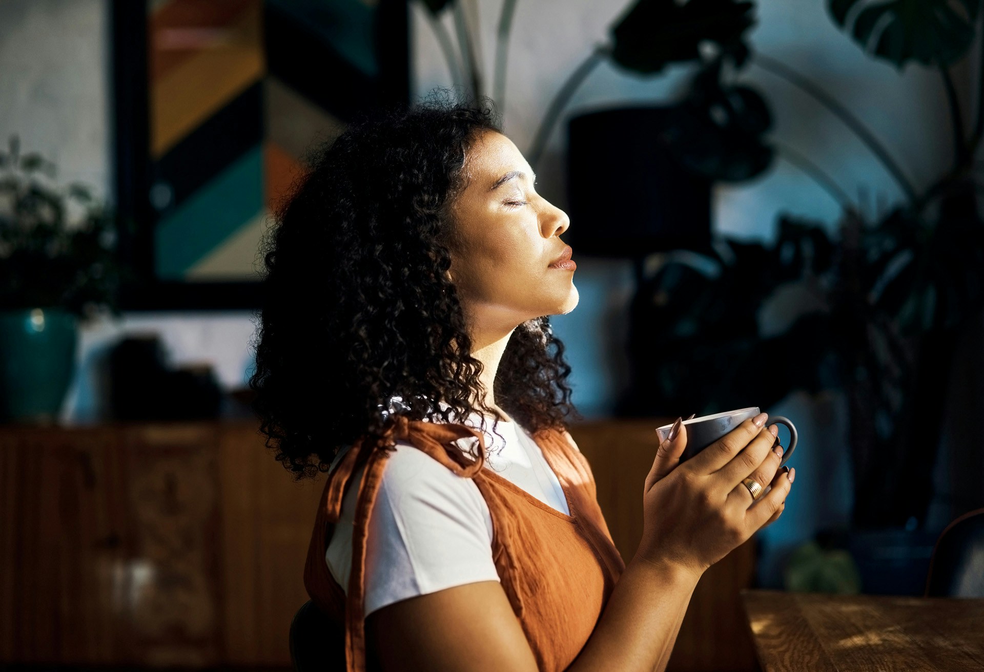 Woman closing her eyes while holding a cup