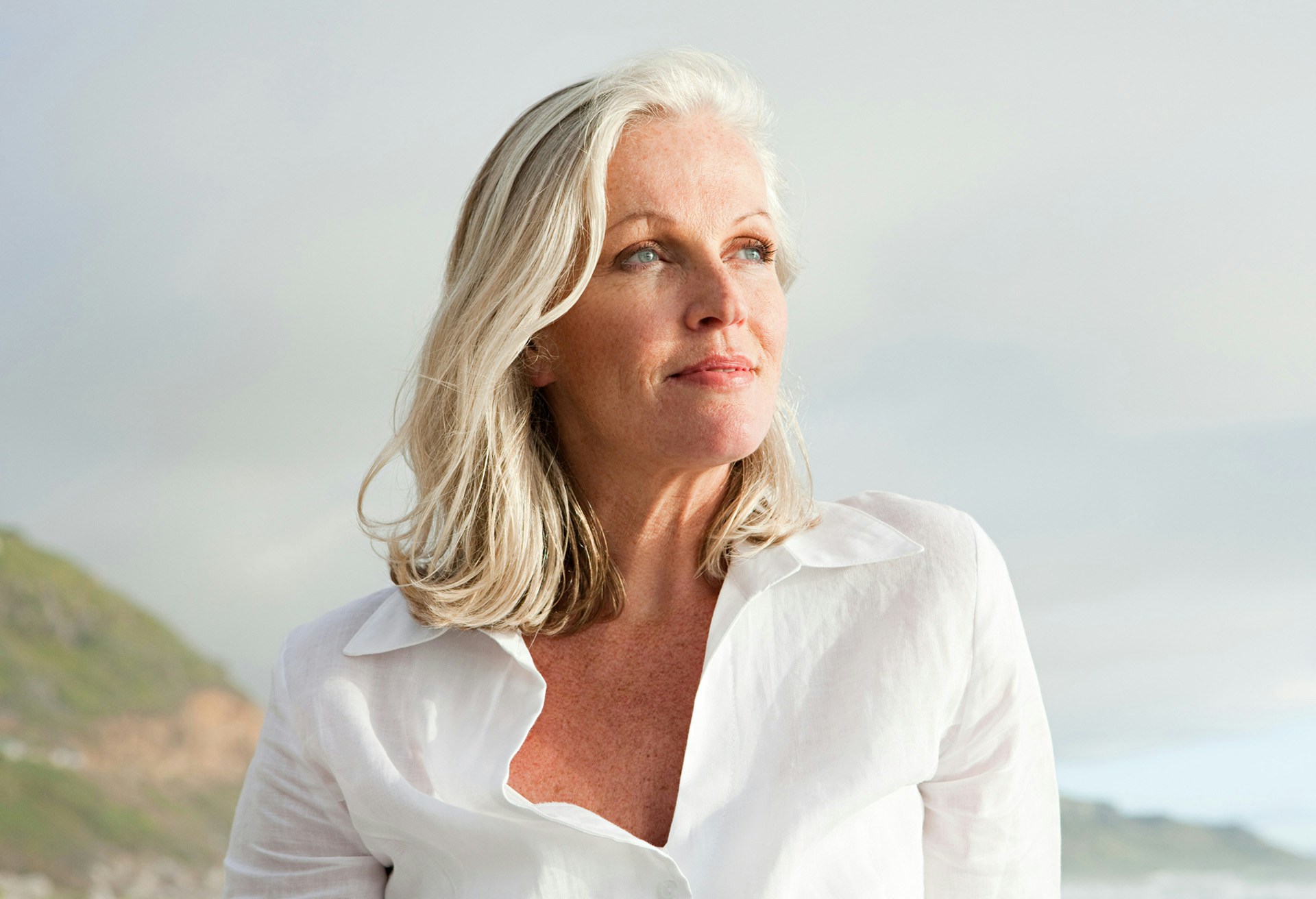 Woman with short grey hair outside looking to the side