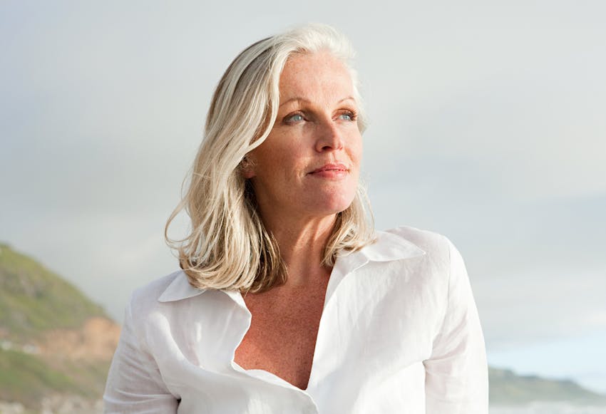 Woman with short grey hair outside looking to the side