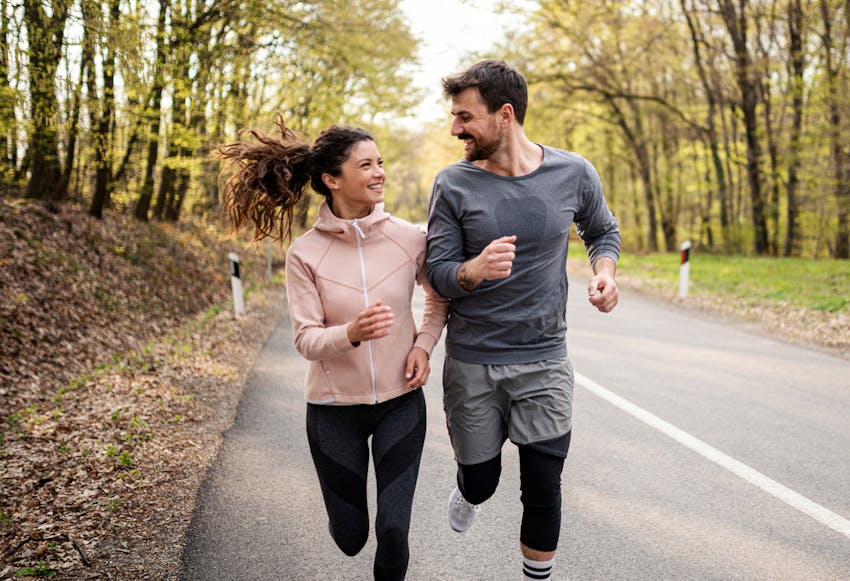 Man and woman running together smiling