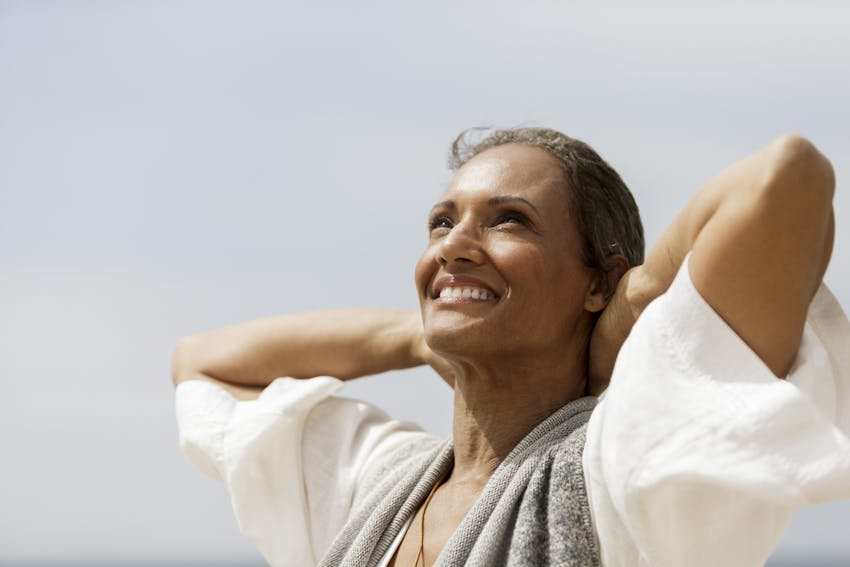 Older woman holding her hands behind her head