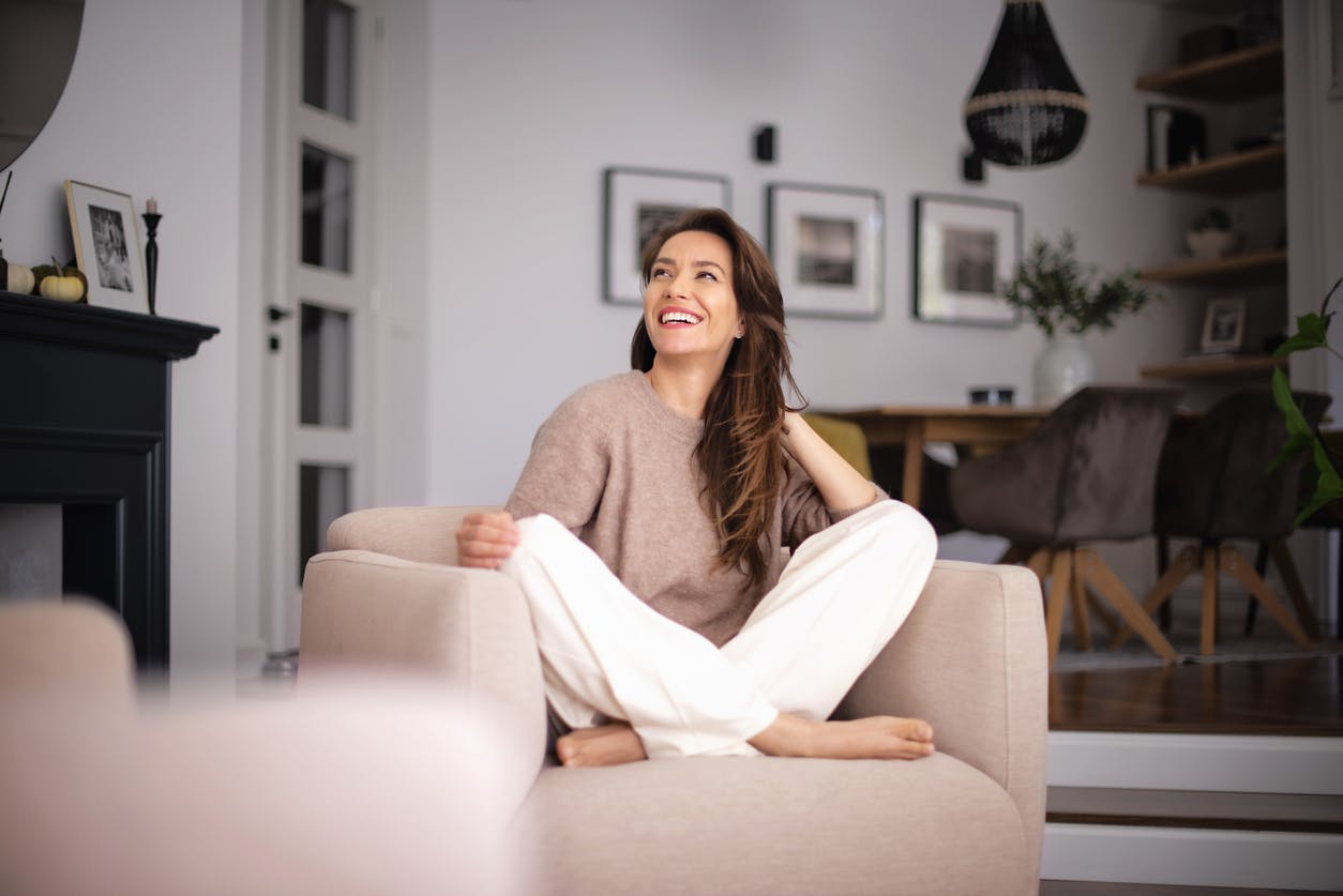 Woman sitting with her legs up on a chair smiling