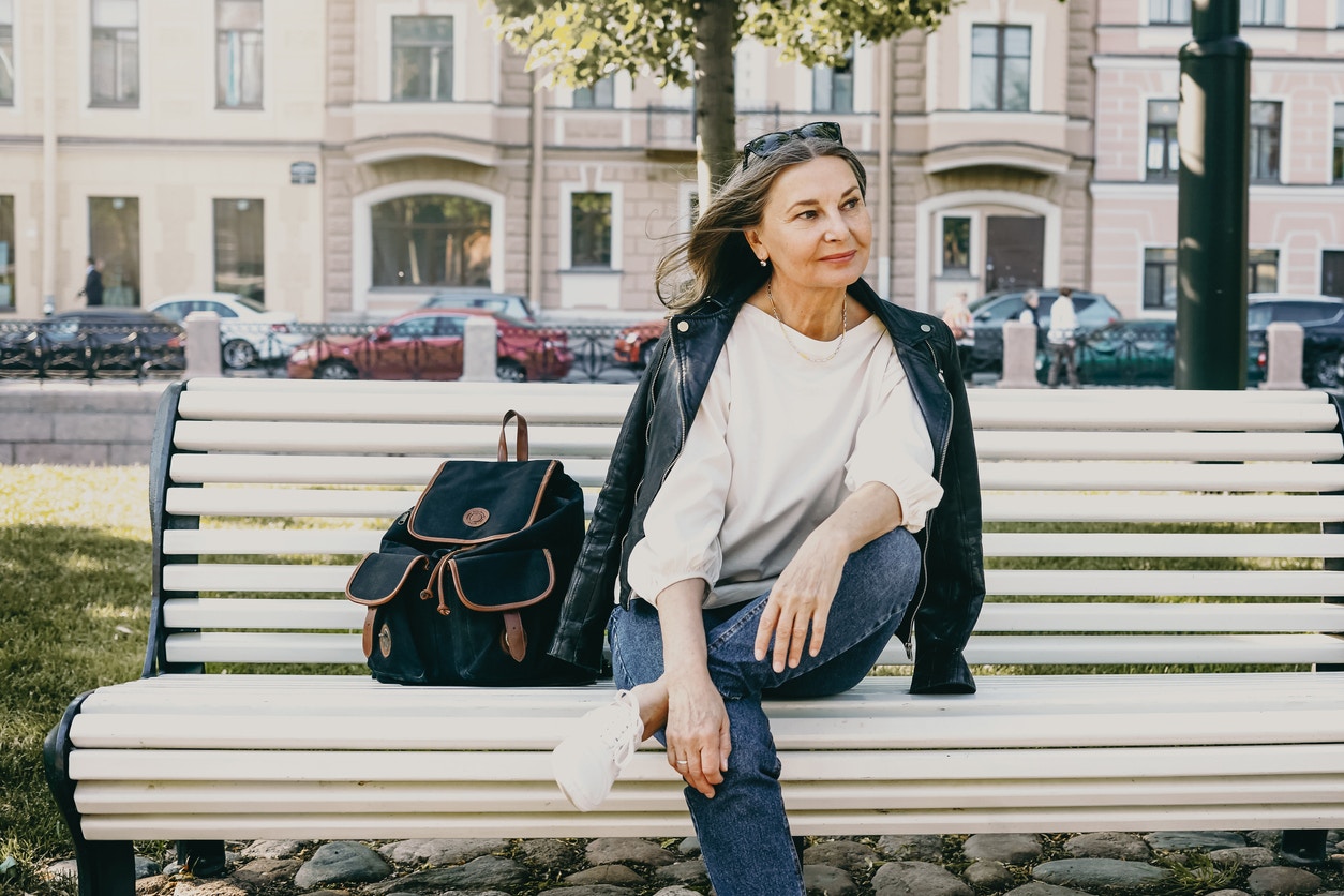 Older chic woman sitting on a bench