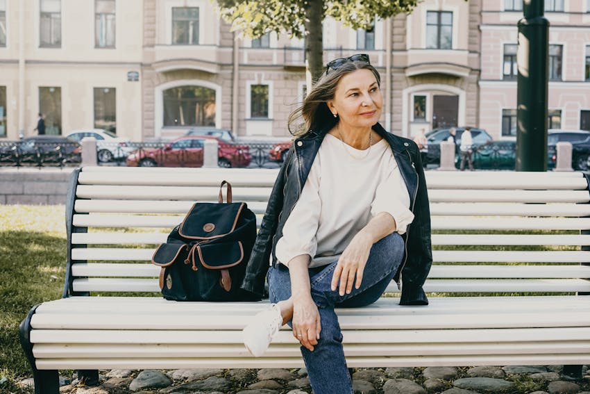 Older chic woman sitting on a bench