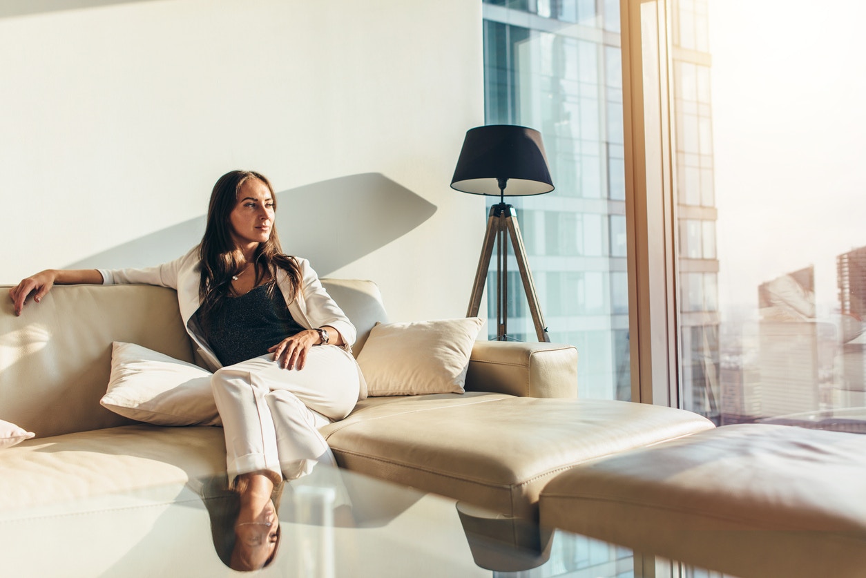 Woman sitting on a couch by a window