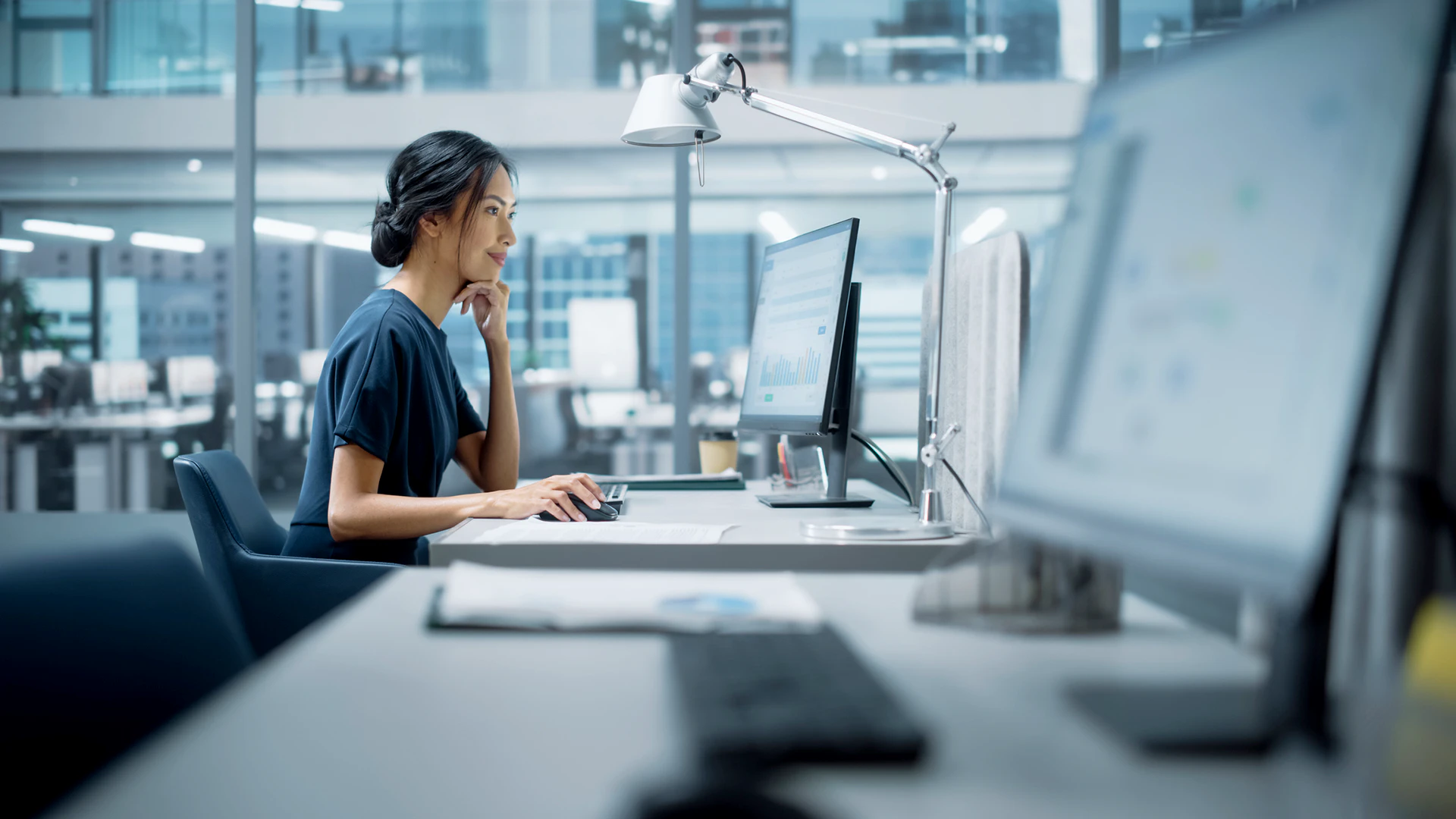 Image of an Asian woman in fron of the computer to represent Asset Optimisation as a Service