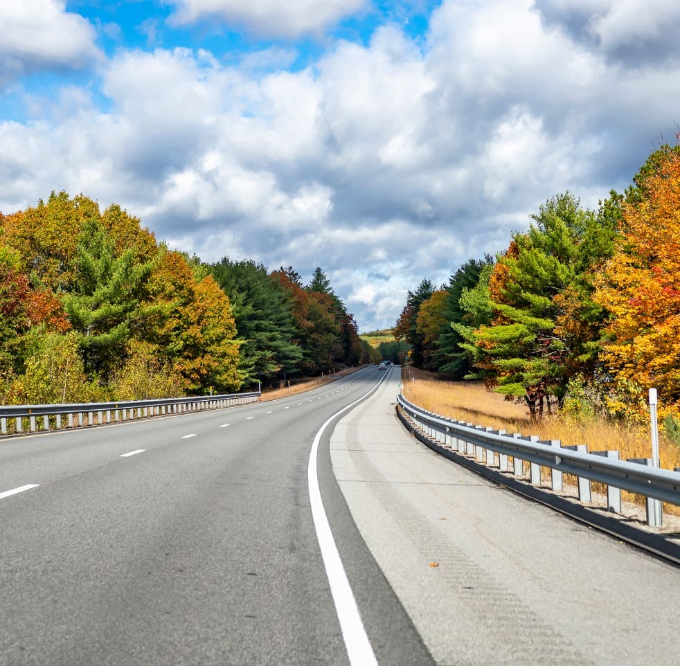 A road surrounded by trees at fall