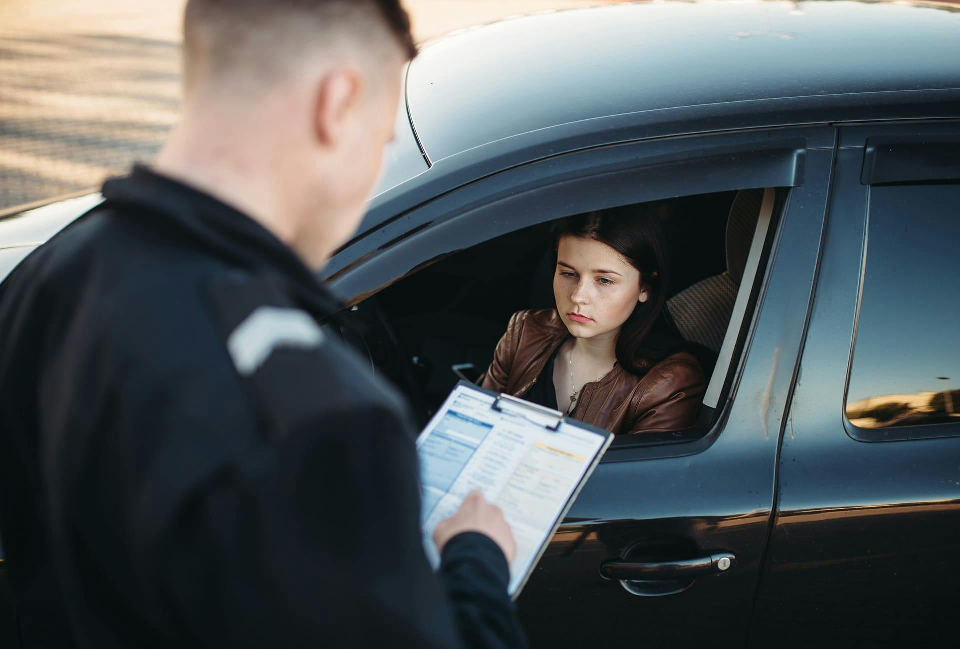 Police officer writing a woman a ticket
