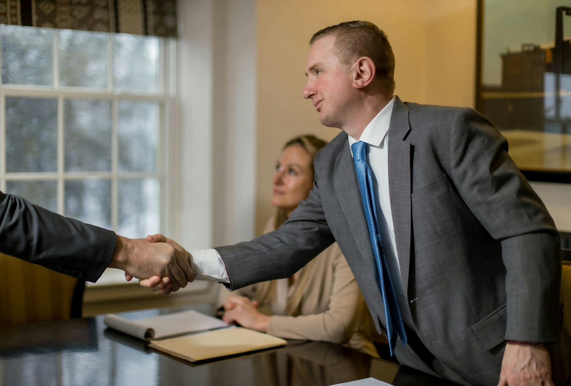 Matthew Gilman shaking hands with a client