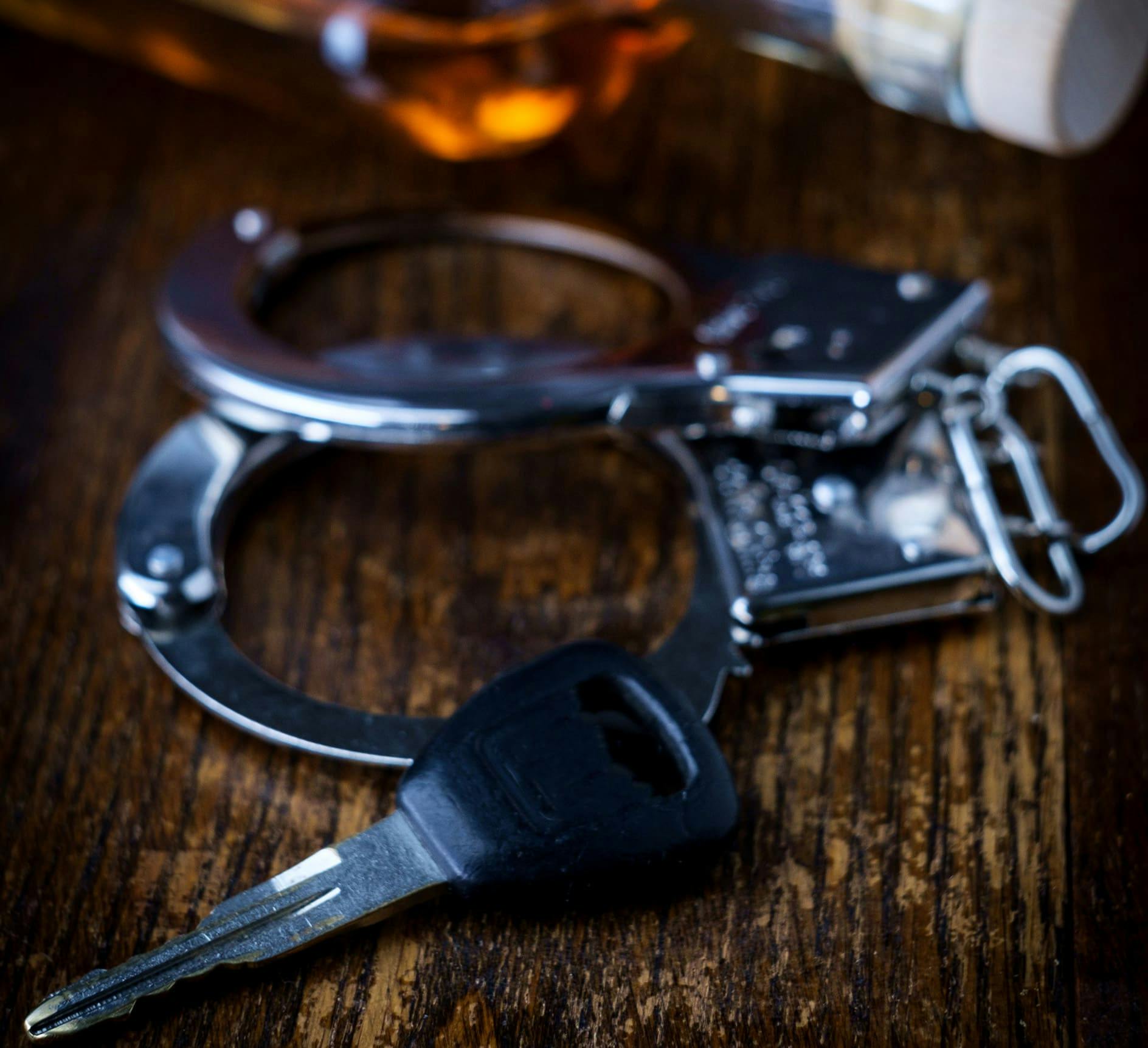 Keys next to handcuffs and alcohol