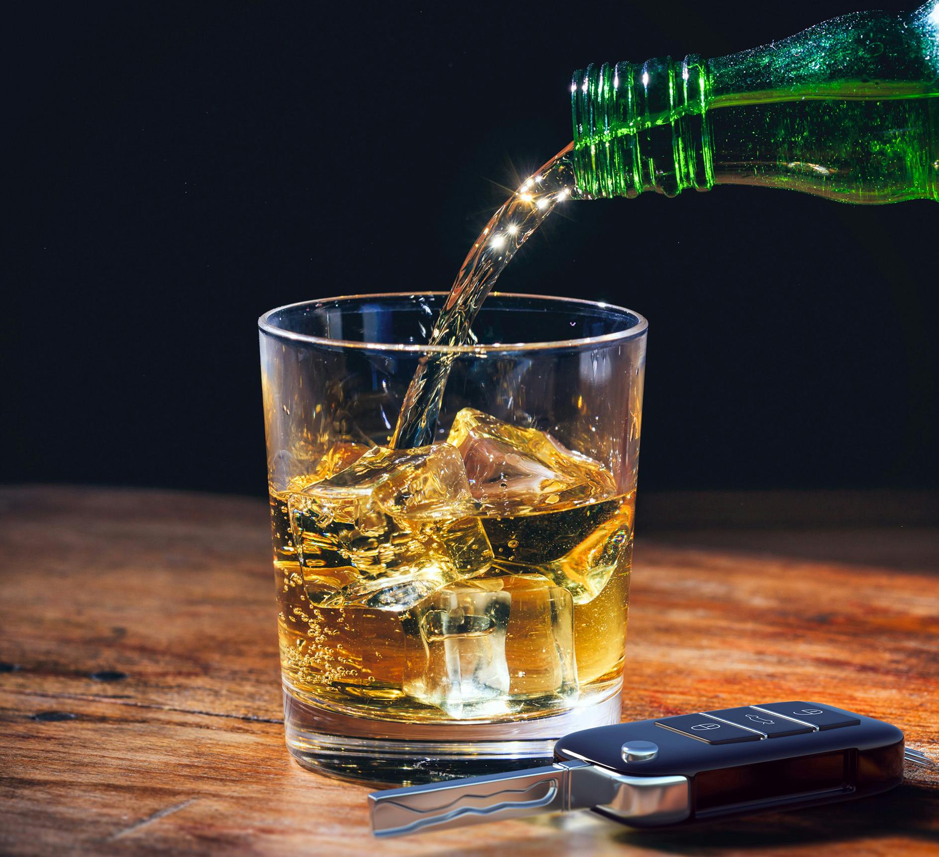 Car key next to a glass of alcohol