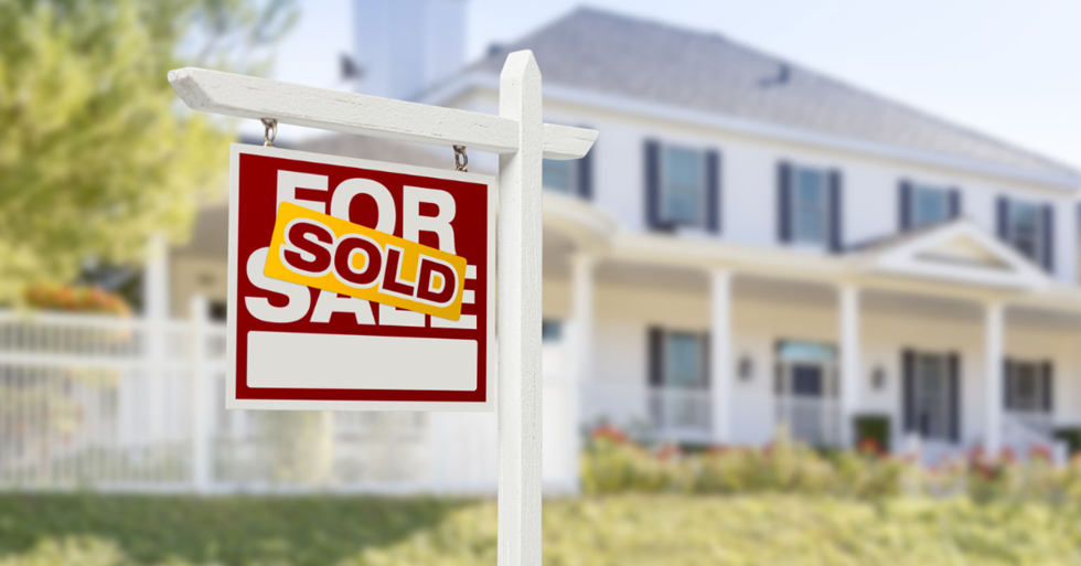 for sale sign in front of a house