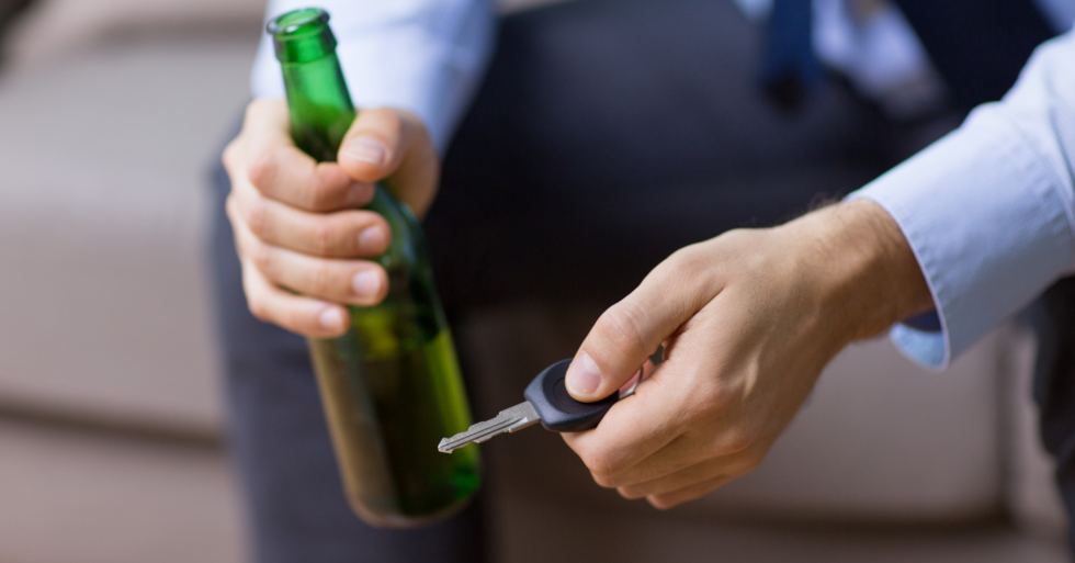 Man holding a bottle and car keys