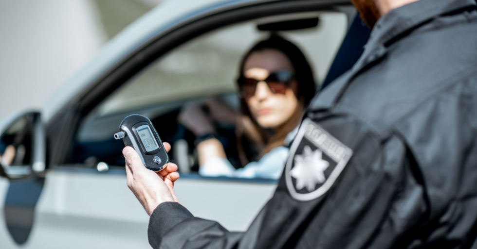 Police officer holding a breathalyzer