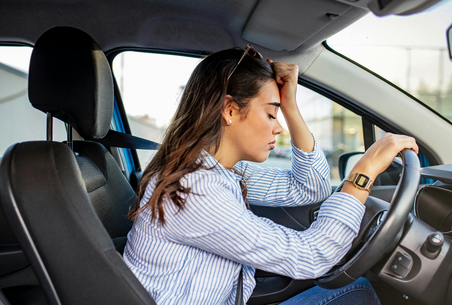 Upset woman leaning on her steering wheel