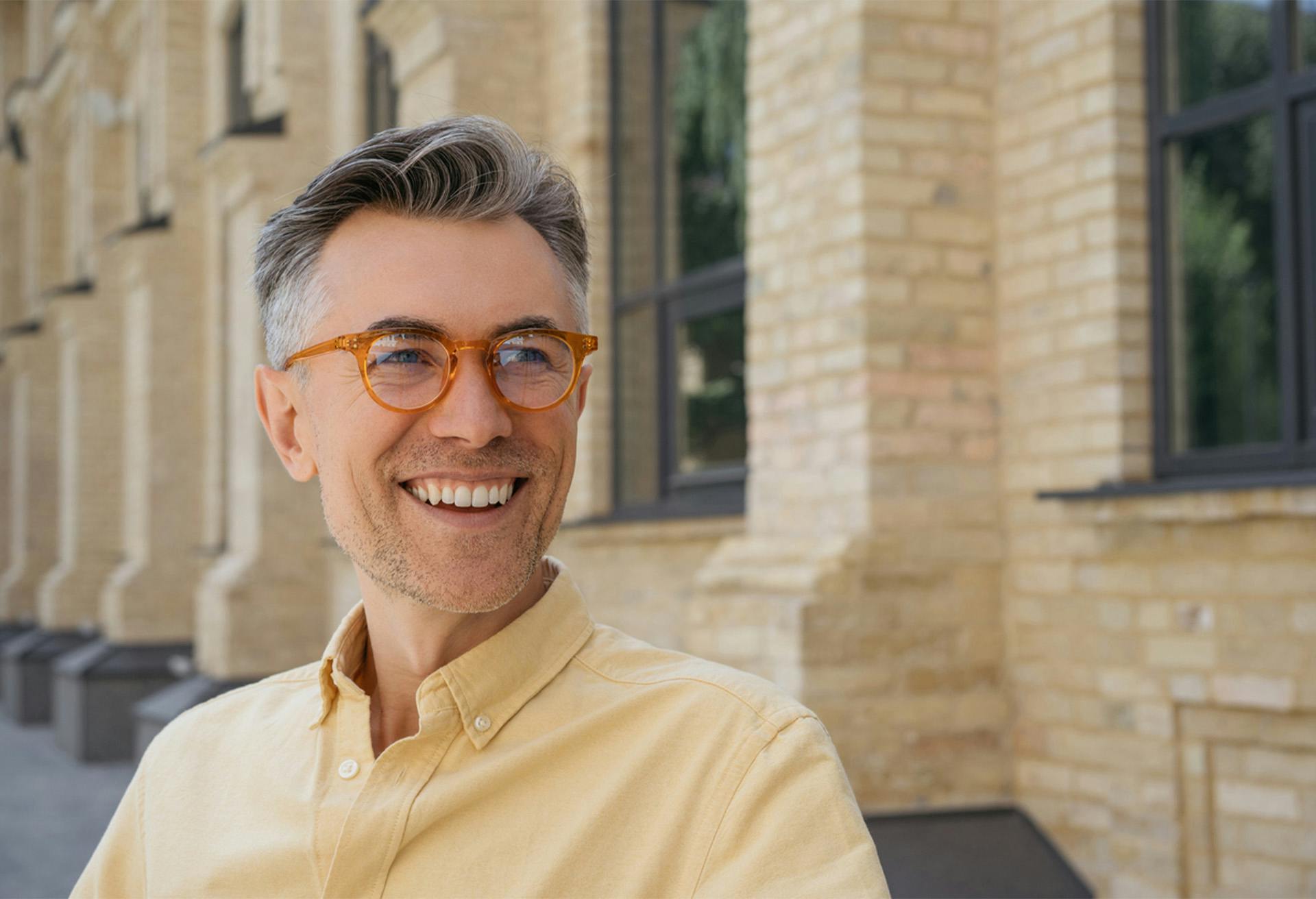 Man with a yellow shirt and glasses