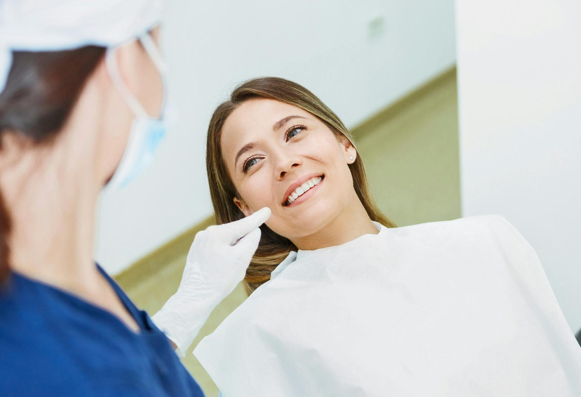 woman in a dentist chair getting her teeth brushed